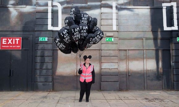 One of the park's purposefully morose employees sells "I Am An Imbecile" balloons. (Photo: Alicia Canter/"The Guardian") 
