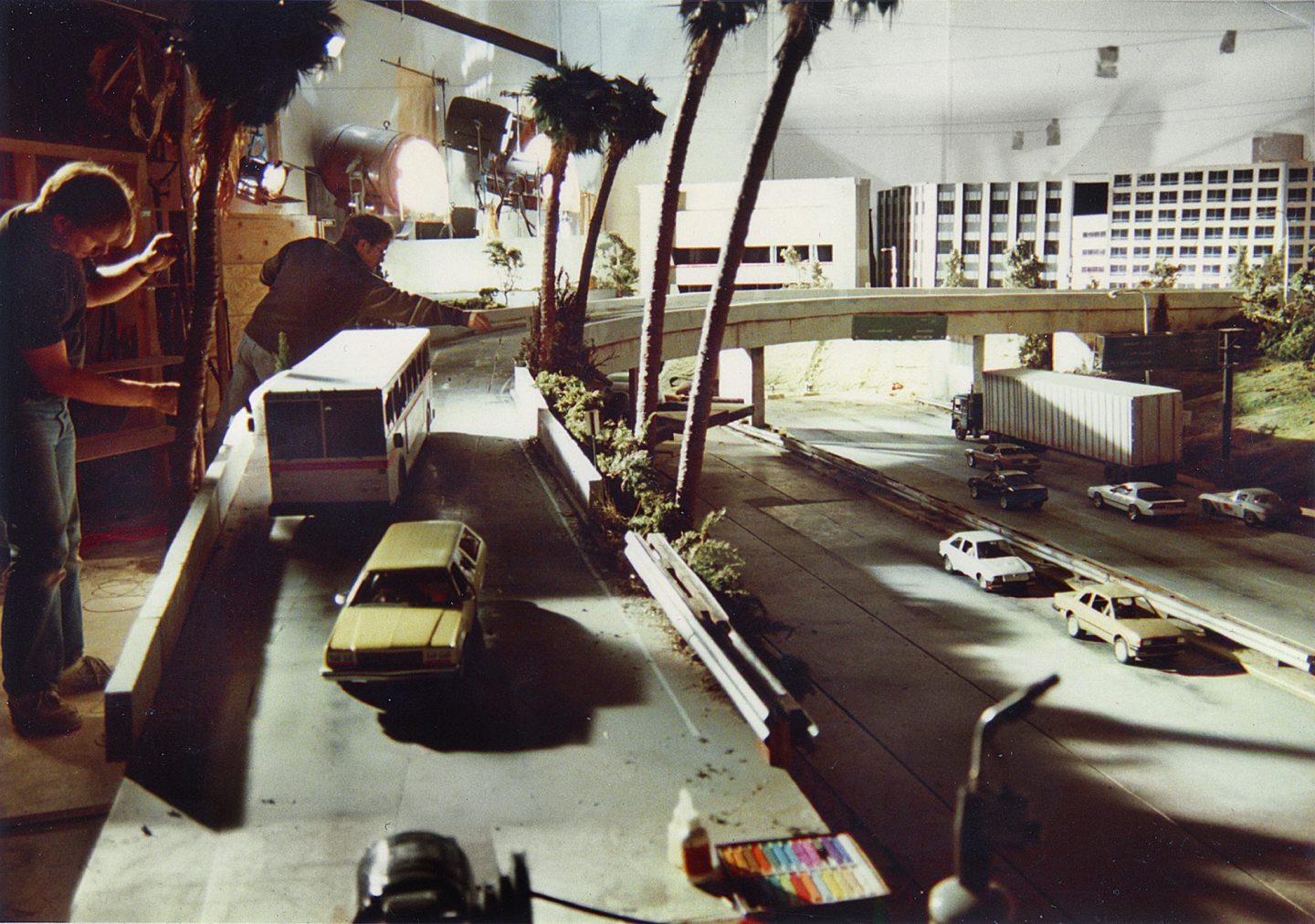 Setting up the freeway miniature. Robert Skotak is leaning over the freeway at rear.
