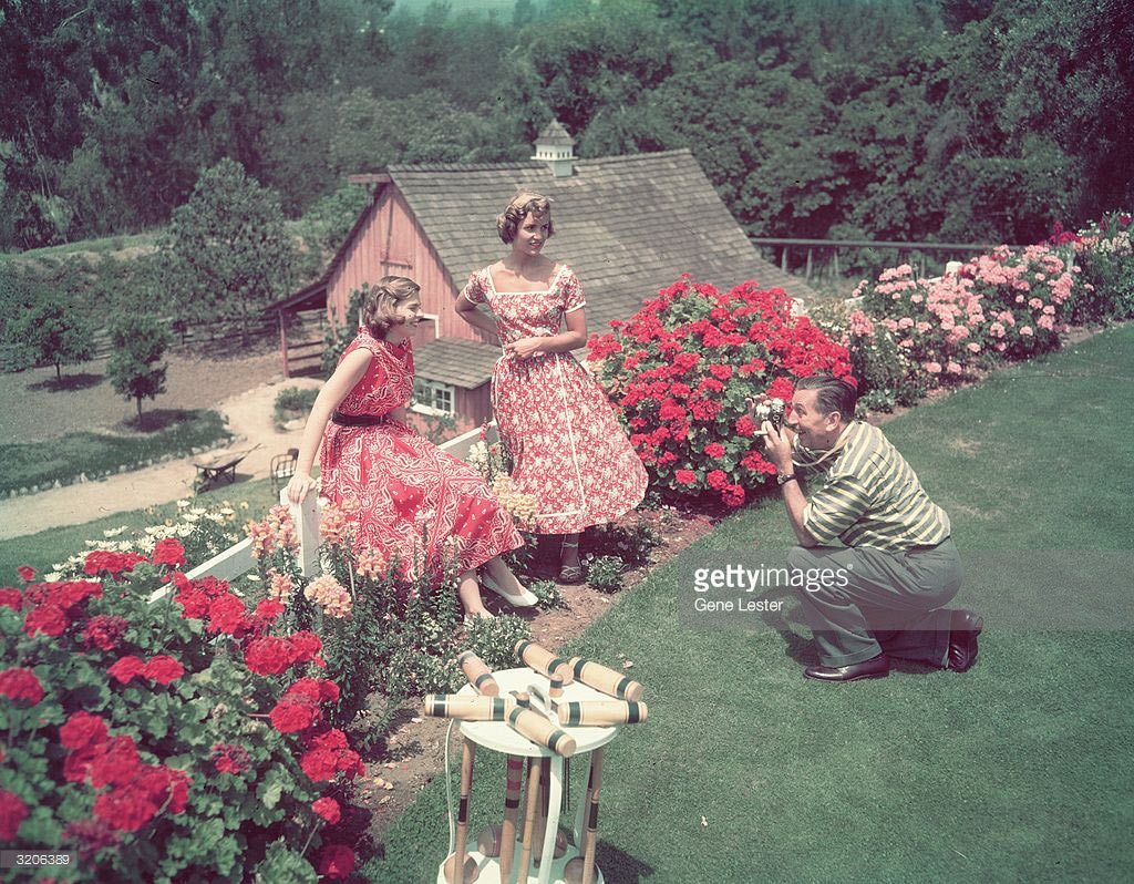 Walt Disney photographing his daughters Diane and Sharon at home.