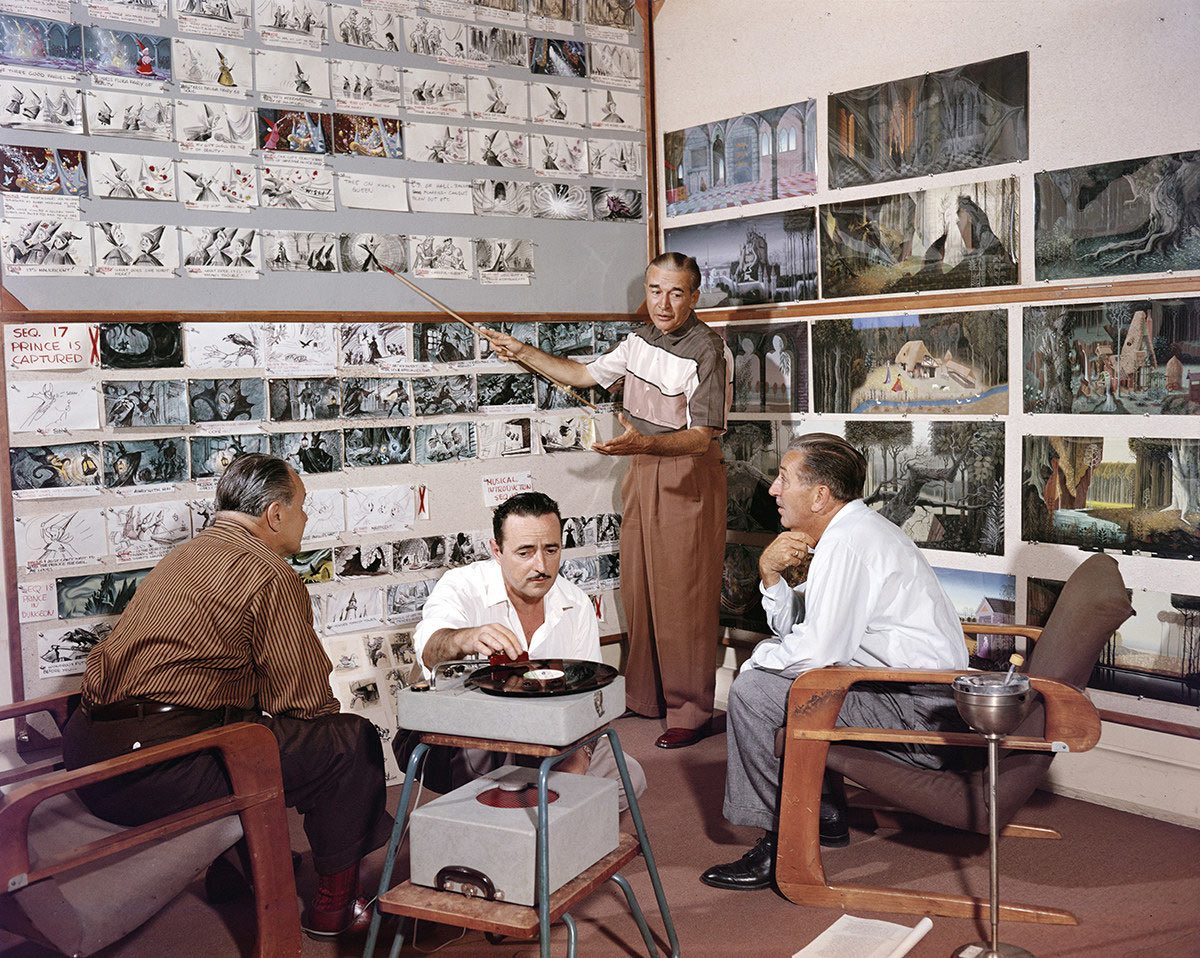 Walt Disney reviewing "Sleeping Beauty" boards with director Clyde Geronimi (left), storyman Joe Rinaldi (middle), and another unidentified person (possibly Ed Penner shortly before his death).