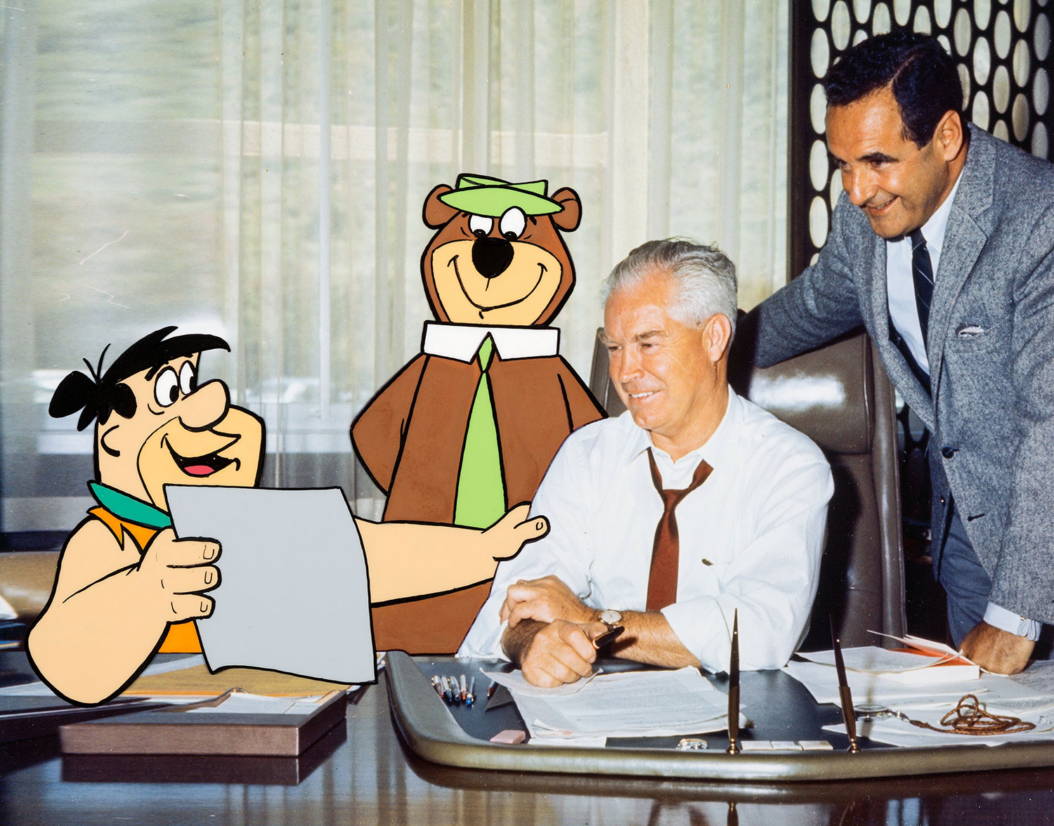 Bill Hanna (left) and Joe Barbera, pose with two of their studio's stars, Fred Flintstone and Yogi Bear.
